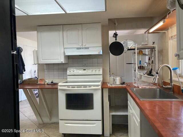 kitchen with white electric range oven, sink, white cabinetry, light tile patterned floors, and backsplash