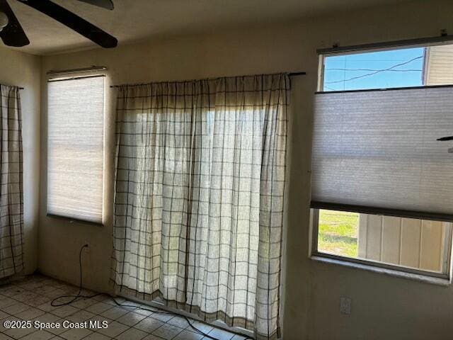 empty room featuring tile patterned flooring and ceiling fan