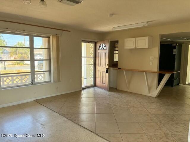 foyer featuring baseboards, visible vents, and a healthy amount of sunlight
