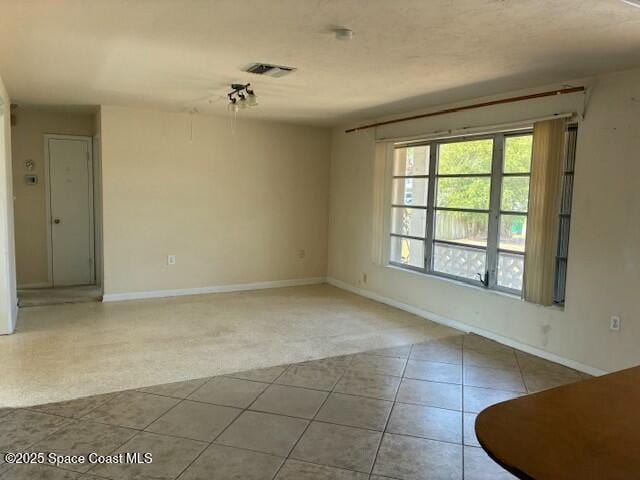 spare room with baseboards, visible vents, and tile patterned floors