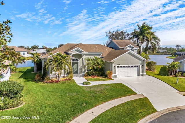 view of front of house with a garage, a front yard, and a water view