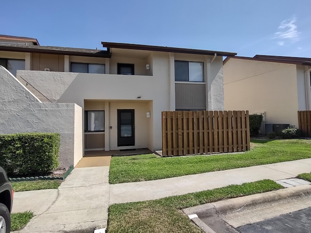 view of front of house featuring a balcony and a front lawn