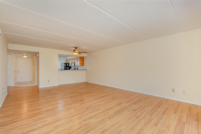 unfurnished living room featuring ceiling fan and light hardwood / wood-style flooring