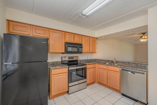 kitchen featuring sink, light tile patterned flooring, a textured ceiling, dark stone countertops, and black appliances