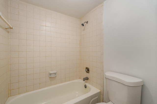 bathroom with toilet and tiled shower / bath combo