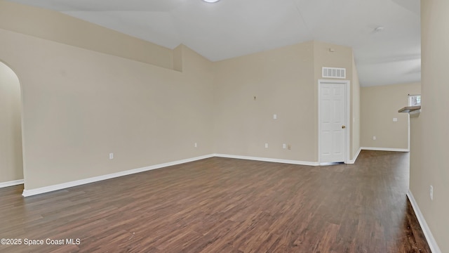 empty room with dark hardwood / wood-style floors and lofted ceiling