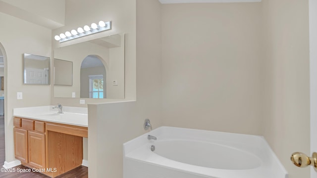 bathroom with hardwood / wood-style floors, vanity, and a bathtub