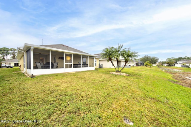 back of property with a yard and a sunroom