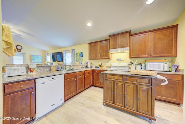 kitchen with white appliances, light hardwood / wood-style floors, sink, kitchen peninsula, and vaulted ceiling