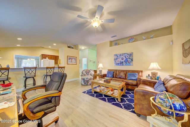 living room with light wood-type flooring, ceiling fan, and lofted ceiling