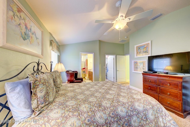 bedroom with ceiling fan, connected bathroom, light carpet, and vaulted ceiling