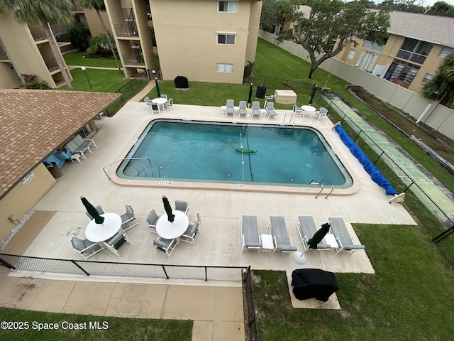 view of swimming pool featuring a patio and a lawn