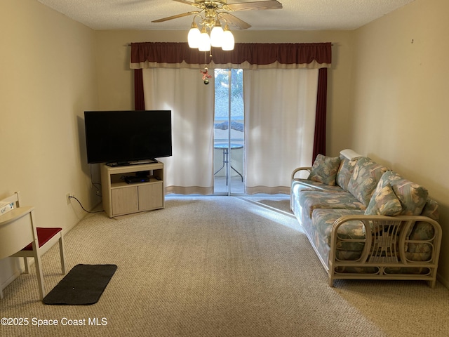 living room with ceiling fan, a textured ceiling, and carpet flooring