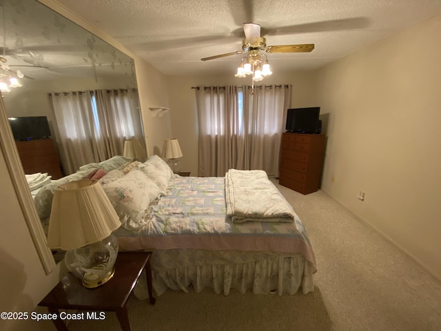 carpeted bedroom with ceiling fan and a textured ceiling