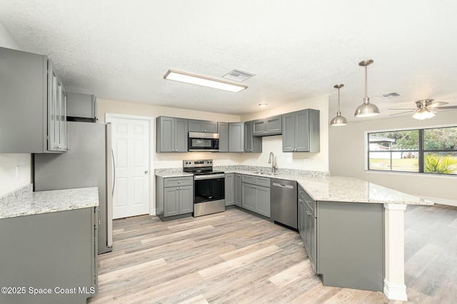 kitchen featuring kitchen peninsula, gray cabinets, sink, and appliances with stainless steel finishes