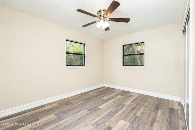 spare room featuring light hardwood / wood-style floors, a textured ceiling, and ceiling fan