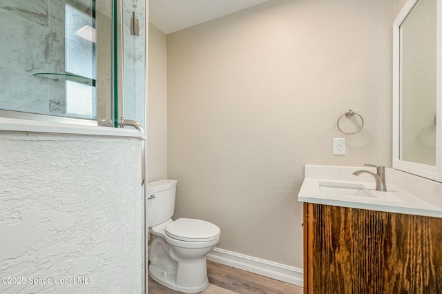 bathroom with hardwood / wood-style flooring, toilet, and vanity