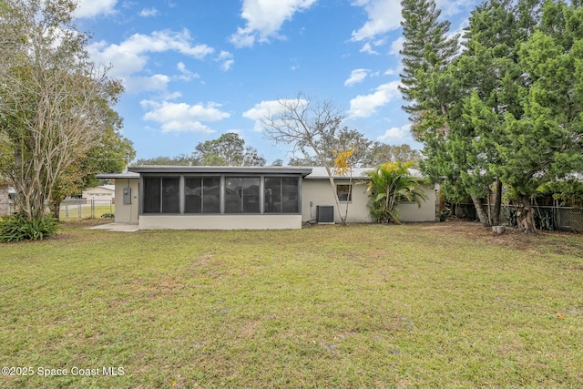 back of house with central AC unit, a sunroom, and a yard