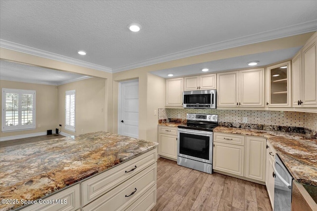 kitchen with crown molding, stone countertops, light wood-type flooring, appliances with stainless steel finishes, and cream cabinetry