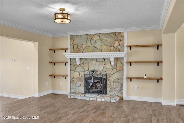 unfurnished living room with ornamental molding, a fireplace, hardwood / wood-style floors, and a textured ceiling