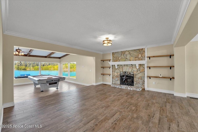 rec room featuring hardwood / wood-style floors, a fireplace, lofted ceiling with beams, and a water view