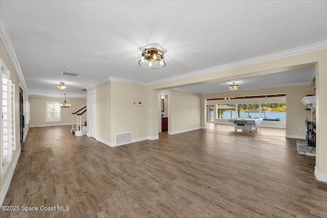 unfurnished living room featuring crown molding, wood-type flooring, and a textured ceiling