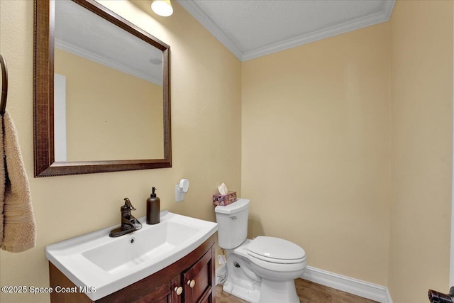 bathroom featuring vanity, crown molding, and toilet