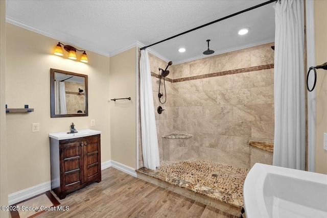 bathroom featuring wood-type flooring, vanity, crown molding, a textured ceiling, and a shower with shower curtain