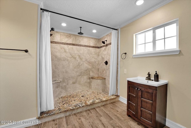 bathroom with crown molding, hardwood / wood-style flooring, a shower with shower curtain, vanity, and a textured ceiling