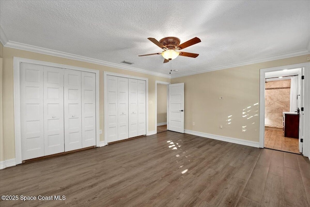 unfurnished bedroom featuring dark hardwood / wood-style flooring, ornamental molding, and ceiling fan