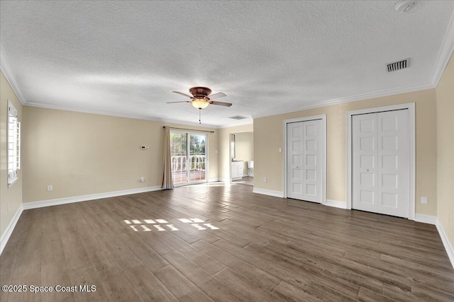 interior space with crown molding, dark hardwood / wood-style floors, ceiling fan, and two closets