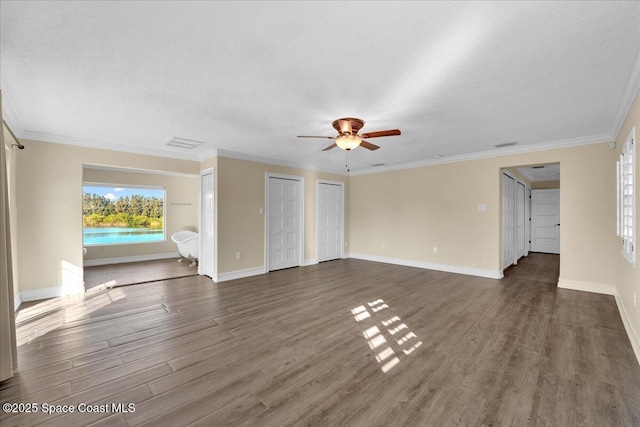 unfurnished living room with crown molding, dark wood-type flooring, and a textured ceiling