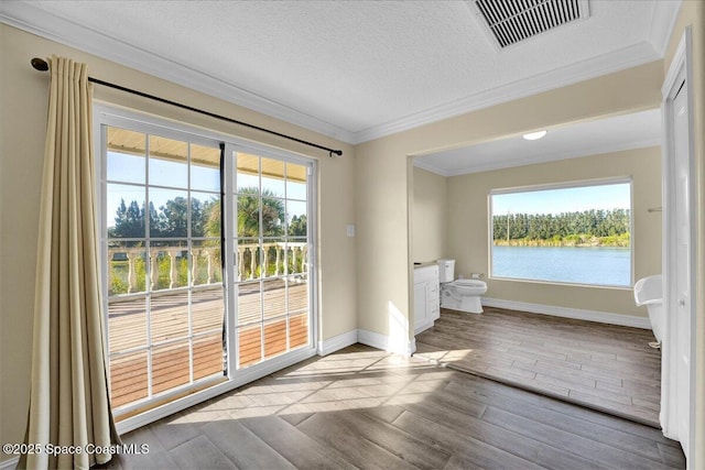 doorway to outside featuring a water view, ornamental molding, and a textured ceiling