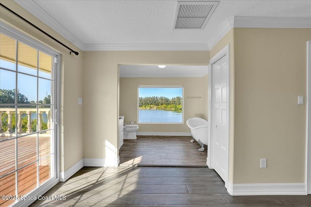 bathroom with crown molding, a water view, wood-type flooring, a textured ceiling, and toilet