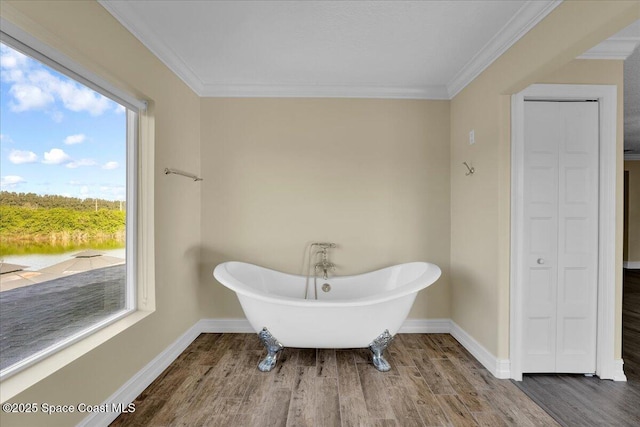 bathroom featuring ornamental molding, wood-type flooring, and a bathing tub