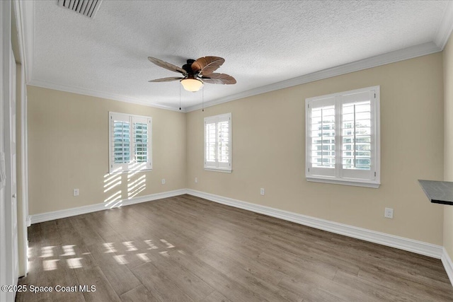 empty room with hardwood / wood-style flooring, ornamental molding, and a healthy amount of sunlight