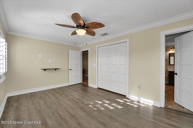 unfurnished bedroom featuring a textured ceiling, wood-type flooring, ornamental molding, and ceiling fan