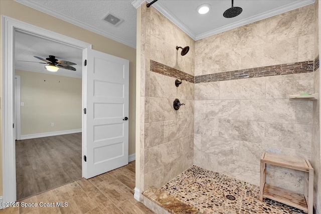 bathroom featuring crown molding, ceiling fan, a textured ceiling, and a tile shower