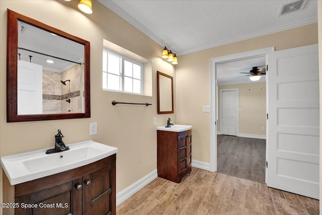 bathroom with walk in shower, a textured ceiling, ornamental molding, vanity, and hardwood / wood-style floors