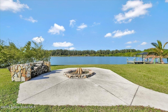 view of patio with a fire pit and a water view