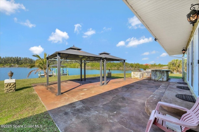 view of patio with a gazebo, a water view, and an outdoor kitchen