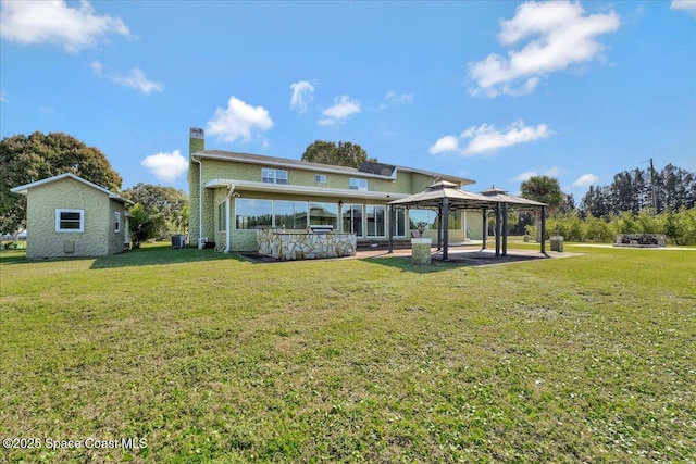 rear view of house featuring a gazebo, a lawn, and cooling unit