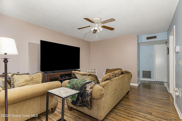 living room with ceiling fan, hardwood / wood-style flooring, and a textured ceiling