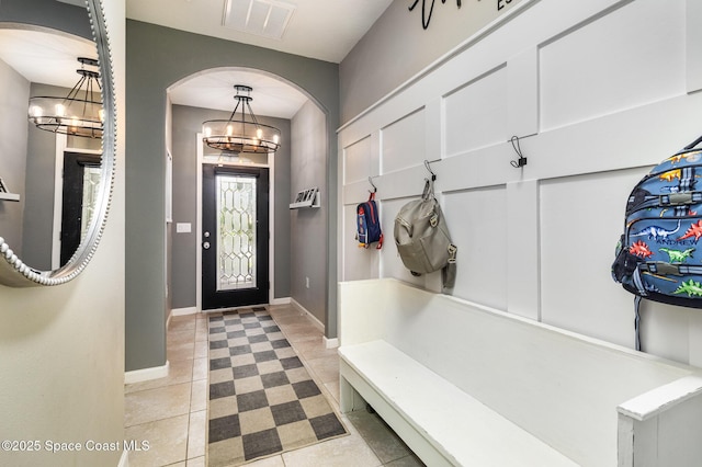 mudroom featuring light tile patterned flooring and an inviting chandelier