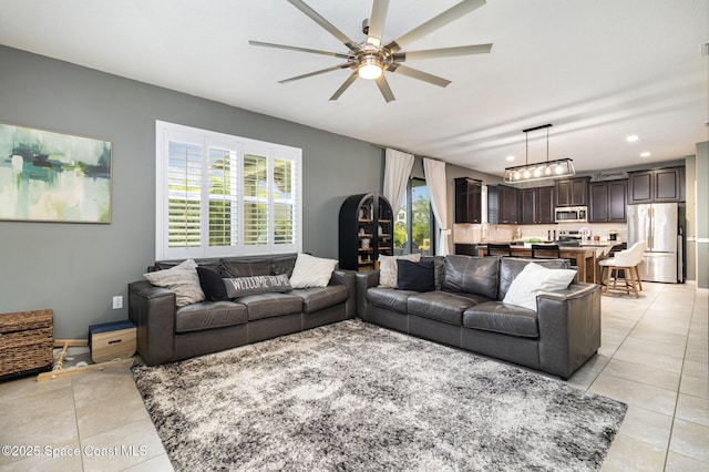 tiled living room featuring a healthy amount of sunlight and ceiling fan