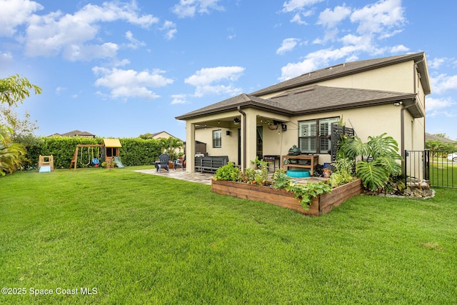 back of house featuring a playground, a patio area, and a yard