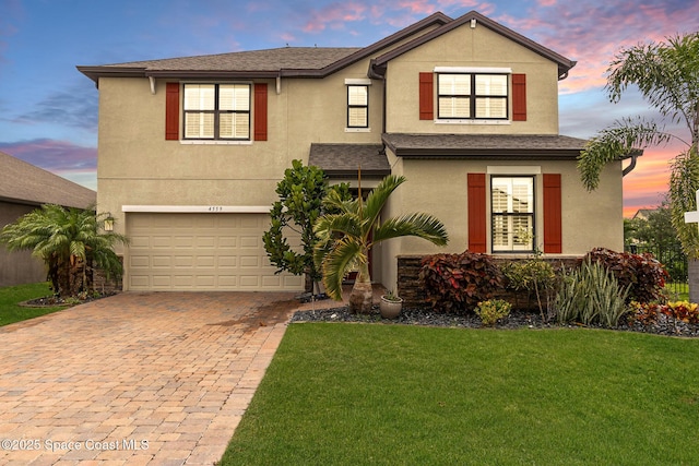 front of property featuring a garage and a yard