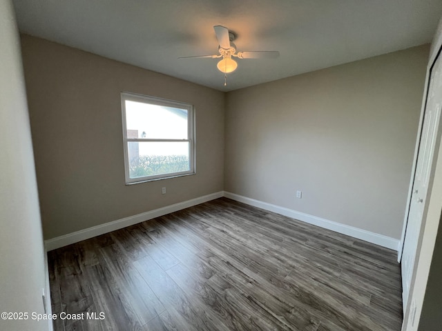 spare room with ceiling fan and dark hardwood / wood-style flooring