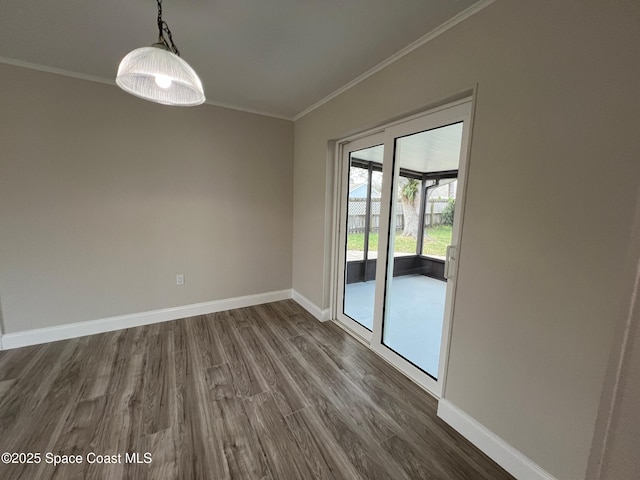 empty room with dark hardwood / wood-style flooring and ornamental molding