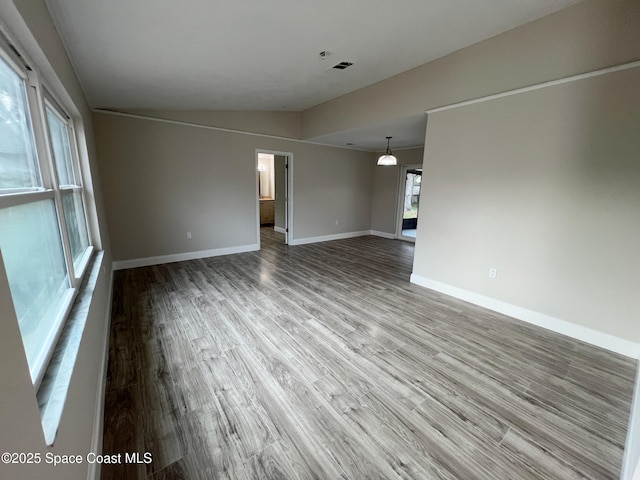 unfurnished room with hardwood / wood-style floors and vaulted ceiling